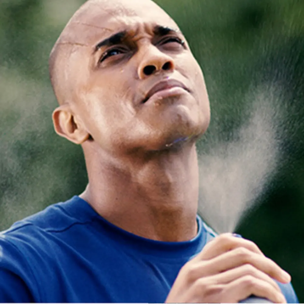hombre rociando su cara con agua 