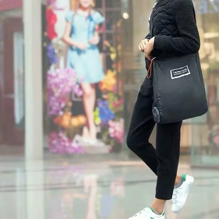 persona caminado por la calle usando bolsa plegable persona caminado por la calle usando bolsa plegable